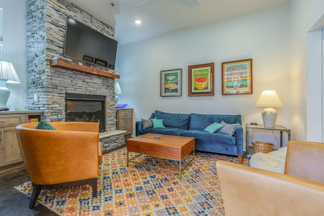 living room featuring a stone fireplace and ceiling fan