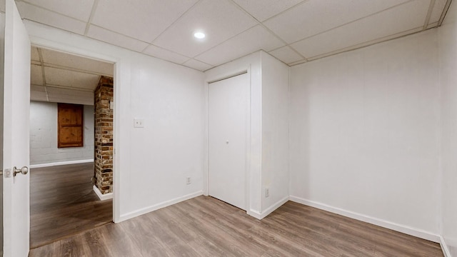 spare room featuring hardwood / wood-style floors and a drop ceiling