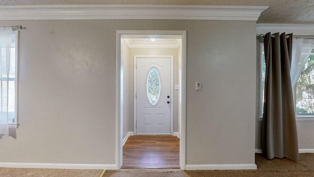 entryway with carpet and ornamental molding