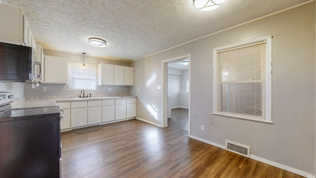 kitchen featuring a textured ceiling, hardwood / wood-style floors, decorative light fixtures, white cabinetry, and electric range