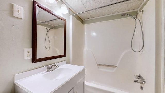 bathroom with vanity,  shower combination, and a paneled ceiling