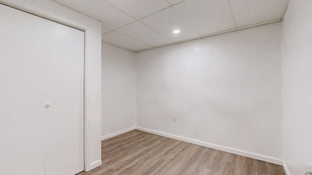 empty room featuring a paneled ceiling and hardwood / wood-style flooring