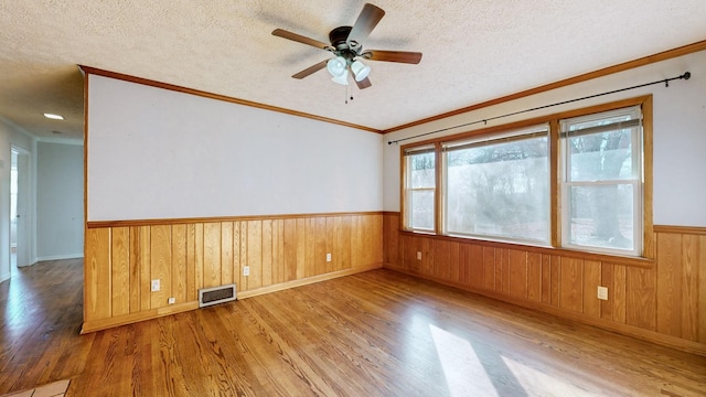 unfurnished room with ceiling fan, crown molding, light hardwood / wood-style floors, and a textured ceiling