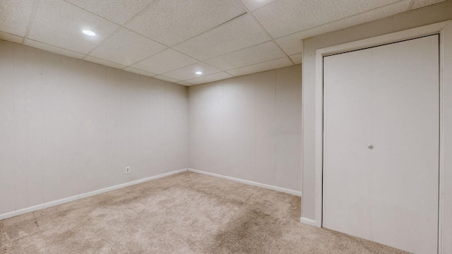 carpeted empty room with a drop ceiling