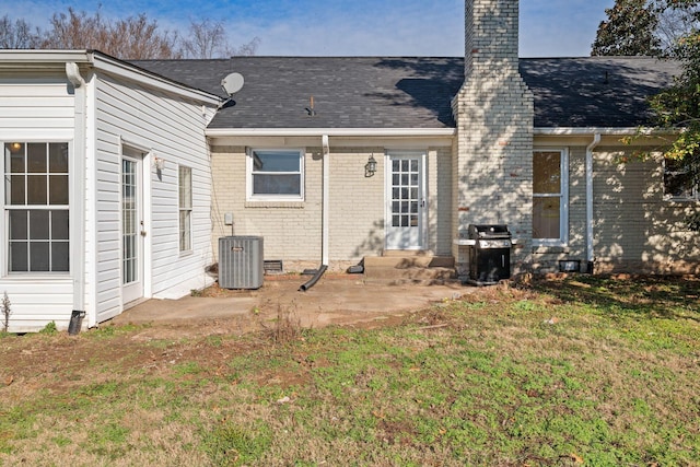 rear view of house featuring a yard, a patio area, and central air condition unit