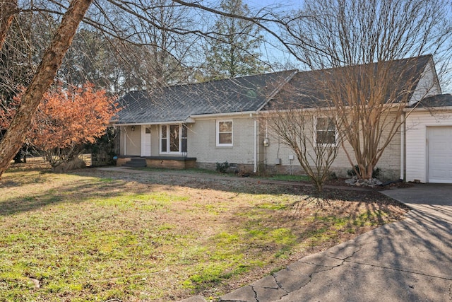 ranch-style house with a garage and a front lawn