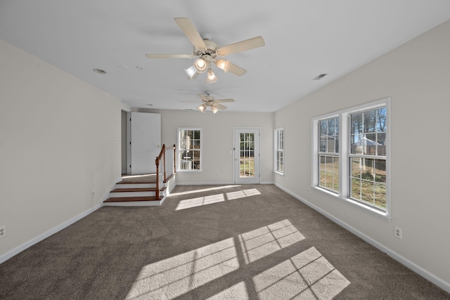 unfurnished living room featuring dark colored carpet and ceiling fan