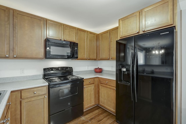 kitchen with black appliances and light hardwood / wood-style floors