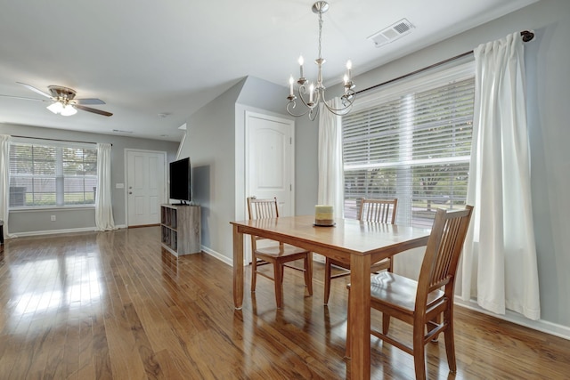 dining space featuring hardwood / wood-style flooring and ceiling fan with notable chandelier