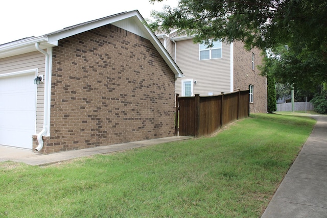 view of side of property featuring a lawn and a garage