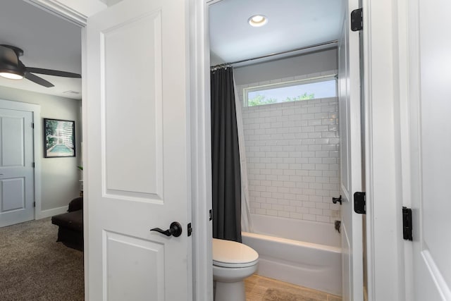 bathroom featuring ceiling fan, toilet, and shower / bath combo with shower curtain