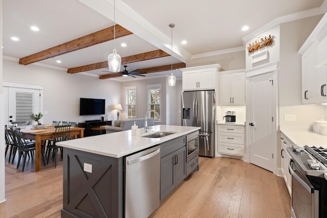 kitchen featuring a center island with sink, ceiling fan, stainless steel appliances, white cabinets, and sink