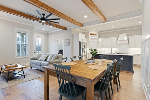 dining area with ceiling fan, beam ceiling, light wood-type flooring, and crown molding