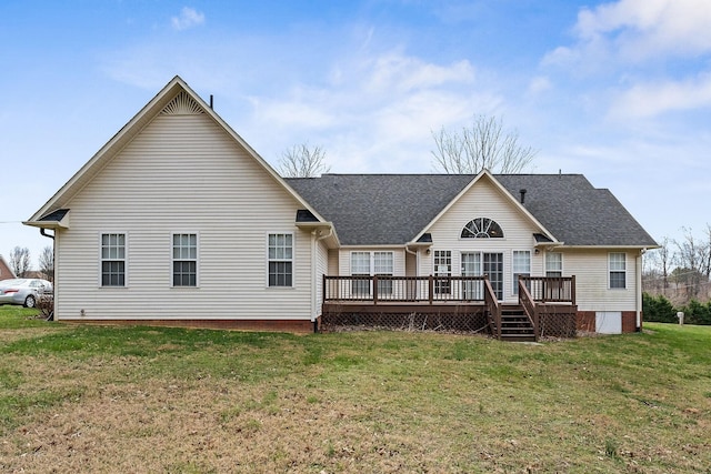 rear view of property with a deck, a shingled roof, and a lawn