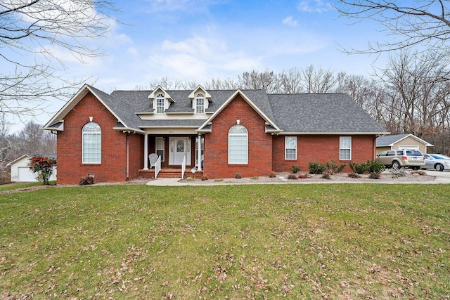 view of front facade with an outdoor structure, a shingled roof, a front lawn, and brick siding