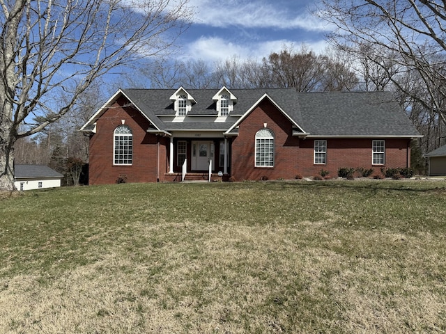 view of front of house with crawl space, roof with shingles, a front yard, and brick siding