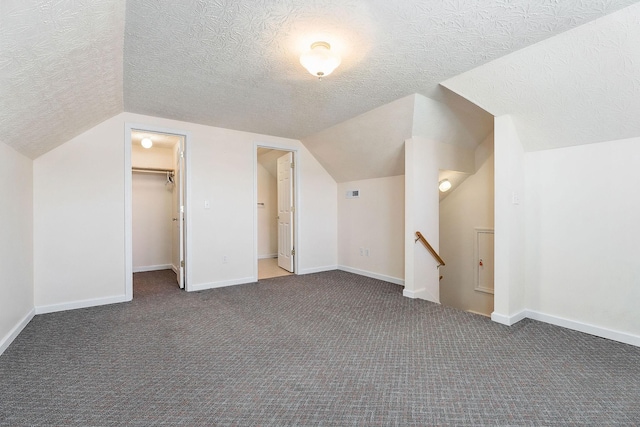 bonus room with lofted ceiling, carpet, and a textured ceiling