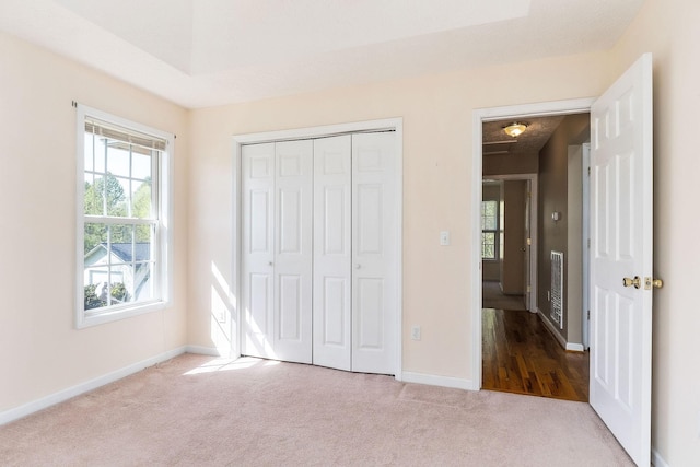 unfurnished bedroom with baseboards, carpet flooring, visible vents, and a closet