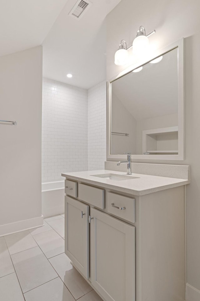 bathroom featuring tile patterned flooring, vanity, and tiled shower / bath combo