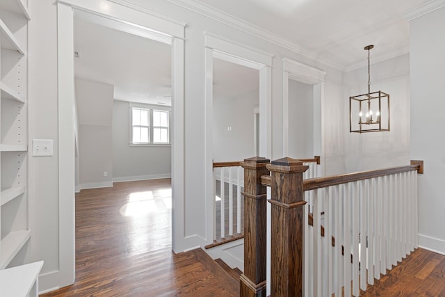 hall with crown molding, dark hardwood / wood-style flooring, and a chandelier