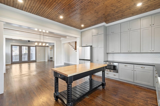 kitchen featuring ceiling fan, stainless steel microwave, french doors, refrigerator, and decorative backsplash