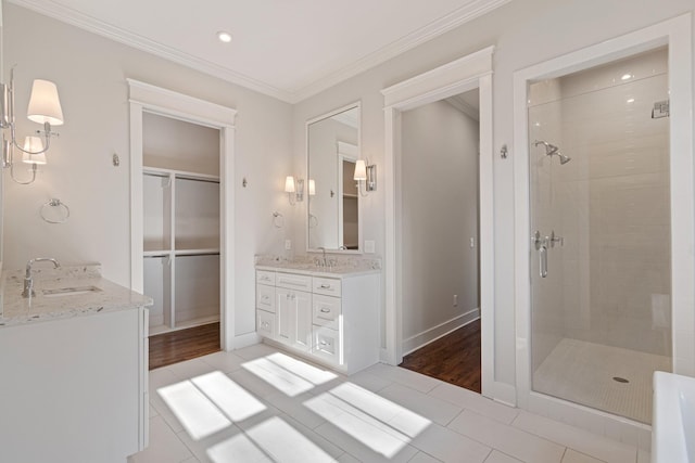 bathroom with tile patterned flooring, vanity, crown molding, and walk in shower