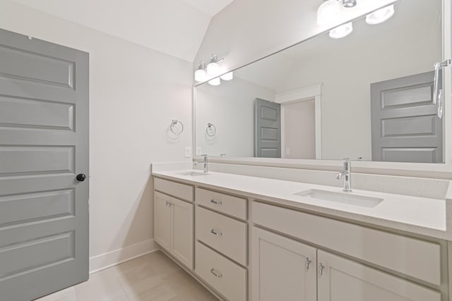 bathroom with tile patterned flooring, vanity, and lofted ceiling