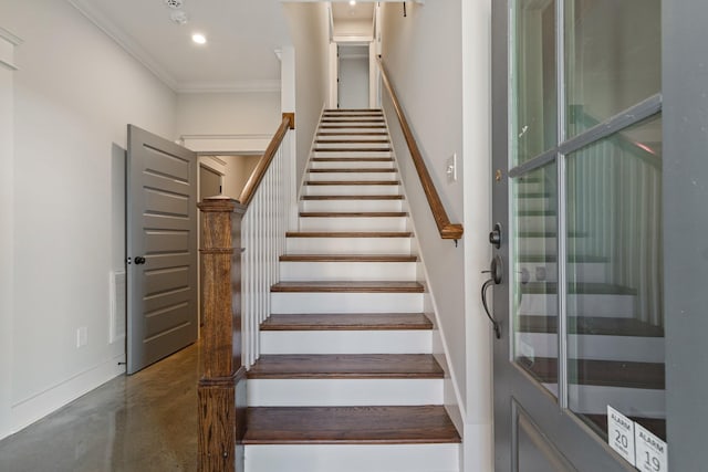 staircase featuring concrete floors and ornamental molding