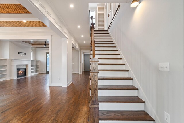 stairs with wood-type flooring, ceiling fan, ornamental molding, and wood ceiling