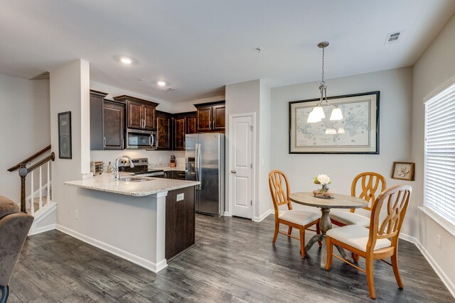 kitchen featuring sink, kitchen peninsula, hanging light fixtures, appliances with stainless steel finishes, and dark brown cabinetry