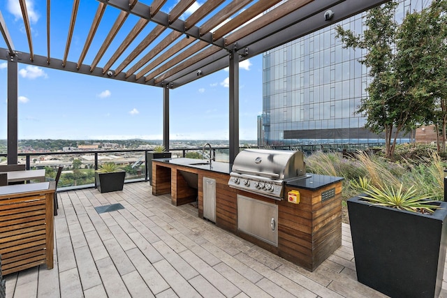 wooden deck with a pergola, grilling area, sink, and exterior kitchen