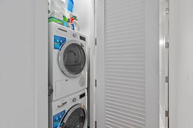 clothes washing area with stacked washer / dryer