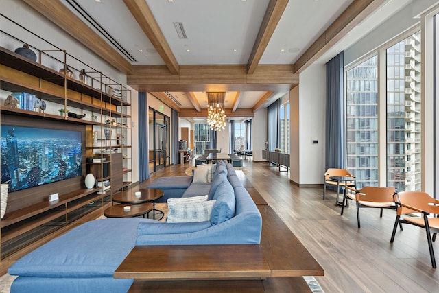 living room with beamed ceiling, plenty of natural light, hardwood / wood-style flooring, and an inviting chandelier