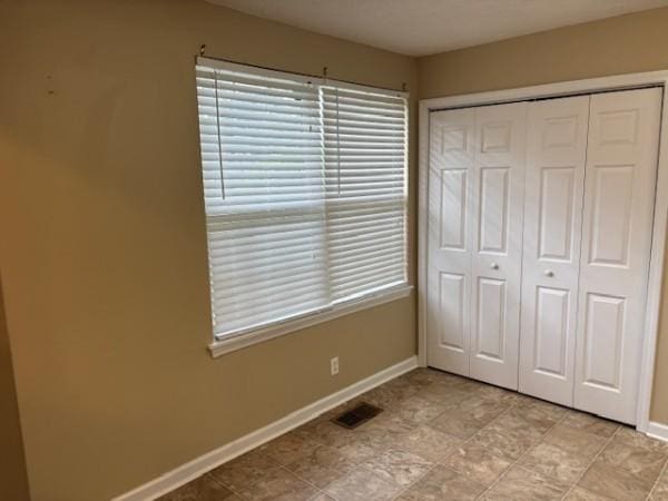 unfurnished bedroom featuring a closet and multiple windows