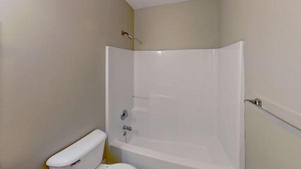 bathroom with toilet and bathing tub / shower combination