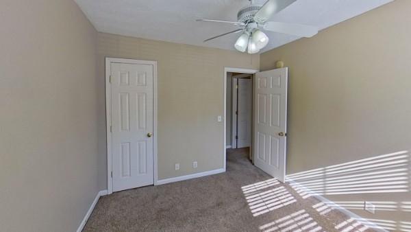 unfurnished bedroom featuring light colored carpet and ceiling fan