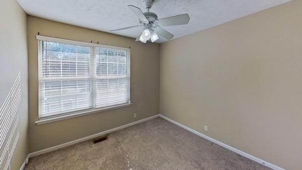 empty room featuring ceiling fan and light carpet