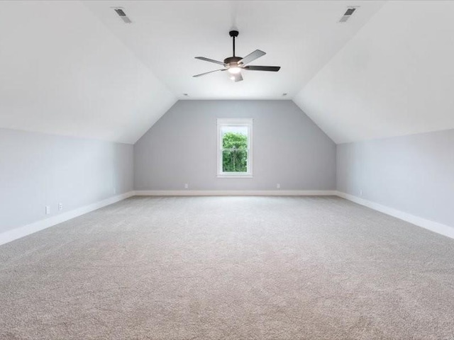 additional living space featuring ceiling fan, light colored carpet, and vaulted ceiling