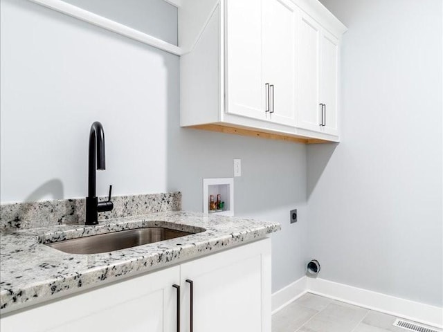 laundry room with electric dryer hookup, cabinets, sink, washer hookup, and light tile patterned floors