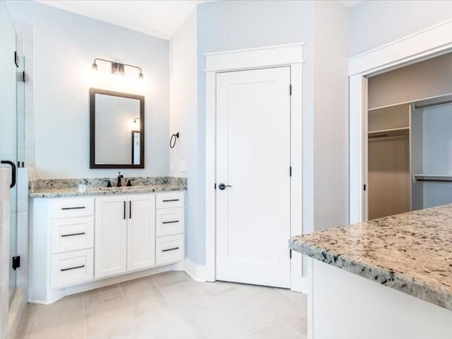 bathroom with tile patterned flooring, vanity, and a shower with shower door