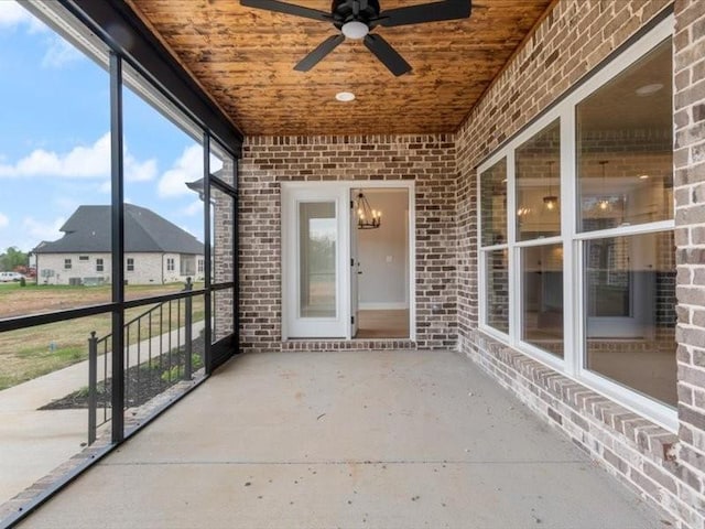 unfurnished sunroom featuring wood ceiling and ceiling fan with notable chandelier