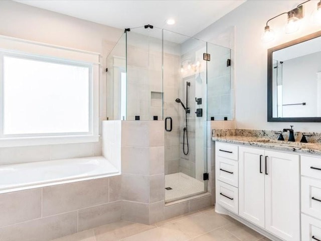 bathroom featuring shower with separate bathtub, vanity, and tile patterned floors