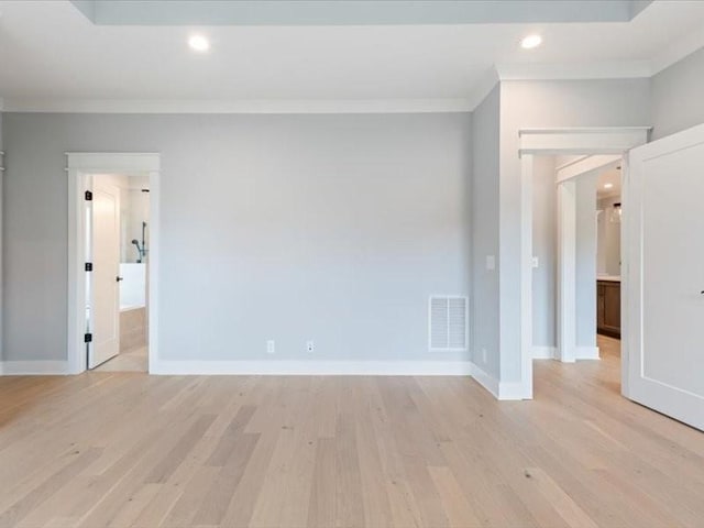 spare room featuring crown molding and light hardwood / wood-style flooring