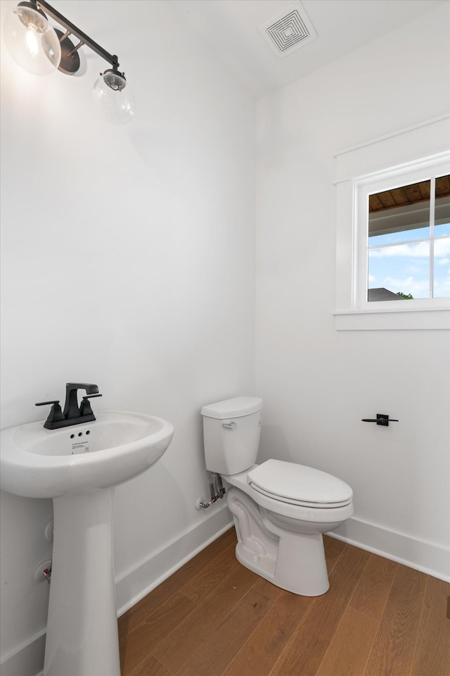 bathroom with wood-type flooring and toilet