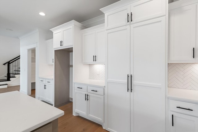 kitchen featuring decorative backsplash, light hardwood / wood-style flooring, and white cabinets