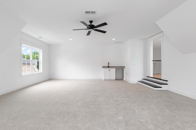 unfurnished living room with ceiling fan and light carpet