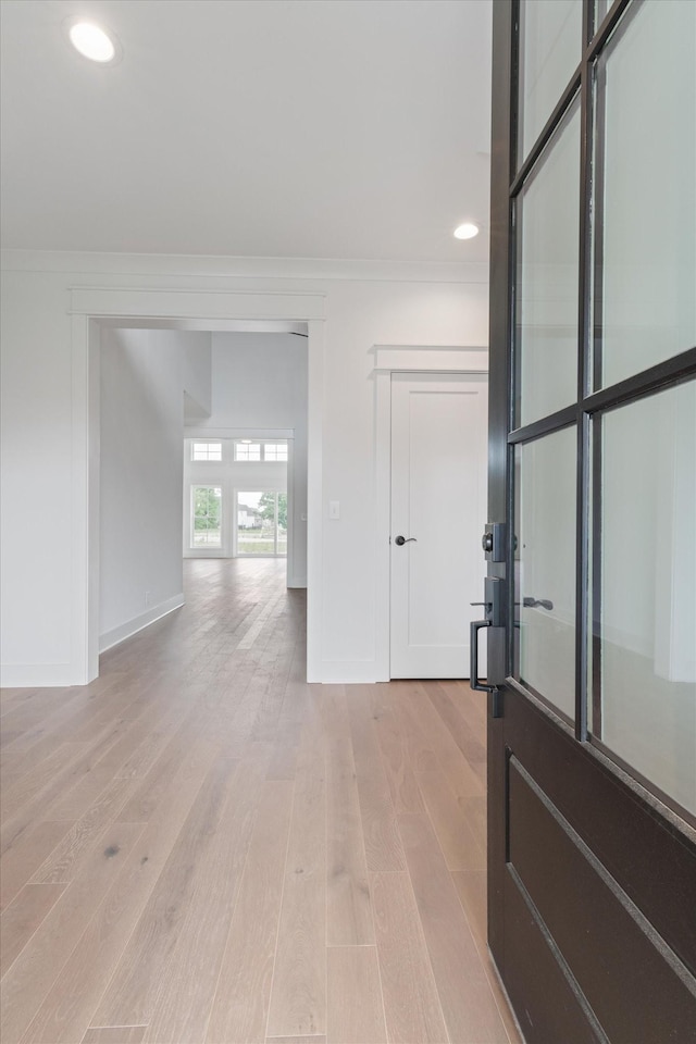 empty room with light hardwood / wood-style floors and crown molding