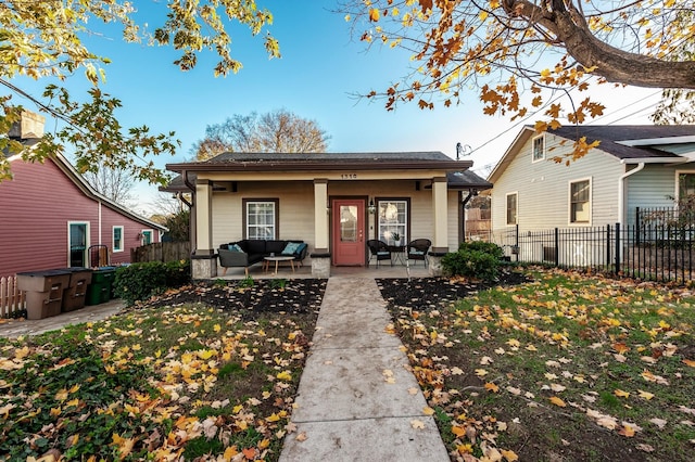 bungalow-style house with a front yard, an outdoor living space, and a patio