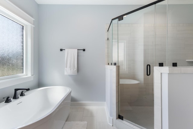 bathroom with tile patterned flooring, independent shower and bath, and a healthy amount of sunlight