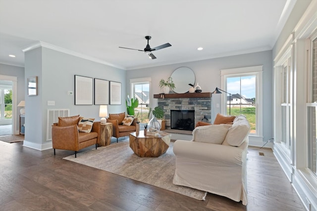 living room with ceiling fan, a fireplace, dark wood-type flooring, and ornamental molding